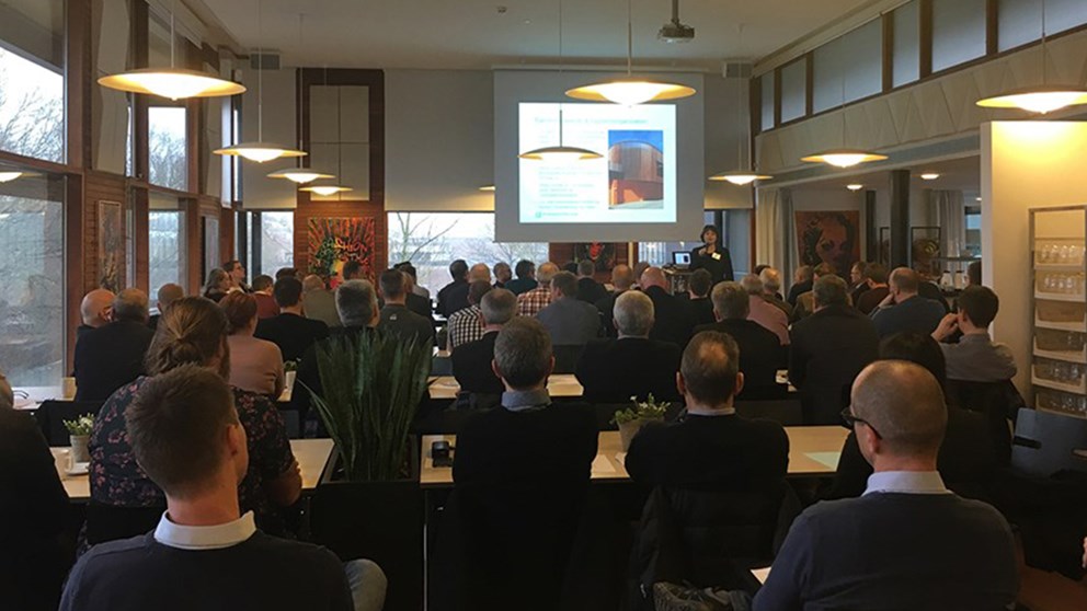 Oplæg på storskærm og deltagere ved entreprenørmøde 2017 i Skanderborg