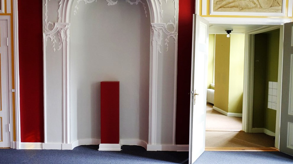 Nyrenoveret rum med rød farve på væggene samt gangareal med sennepsgul farve på væggene